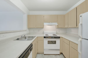 bright kitchen, white appliances, light brown cabinets